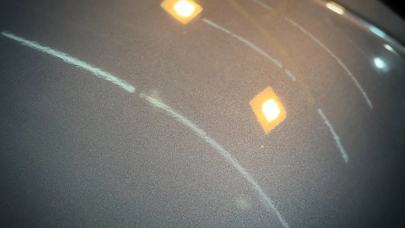 Pintura gris bajo la luz del taller, donde se ven los detalles a corregir